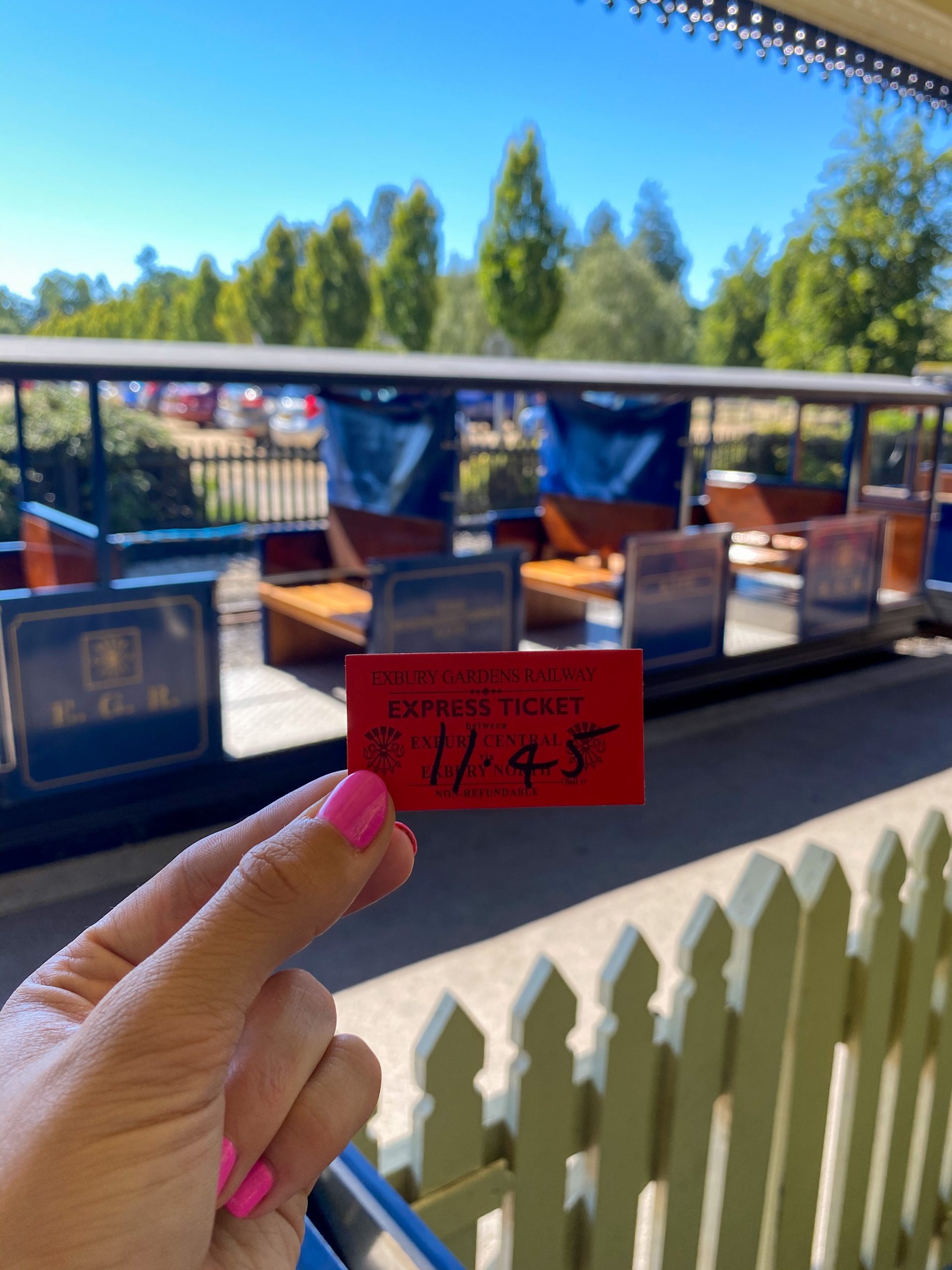 train ticket held up in front of steam train