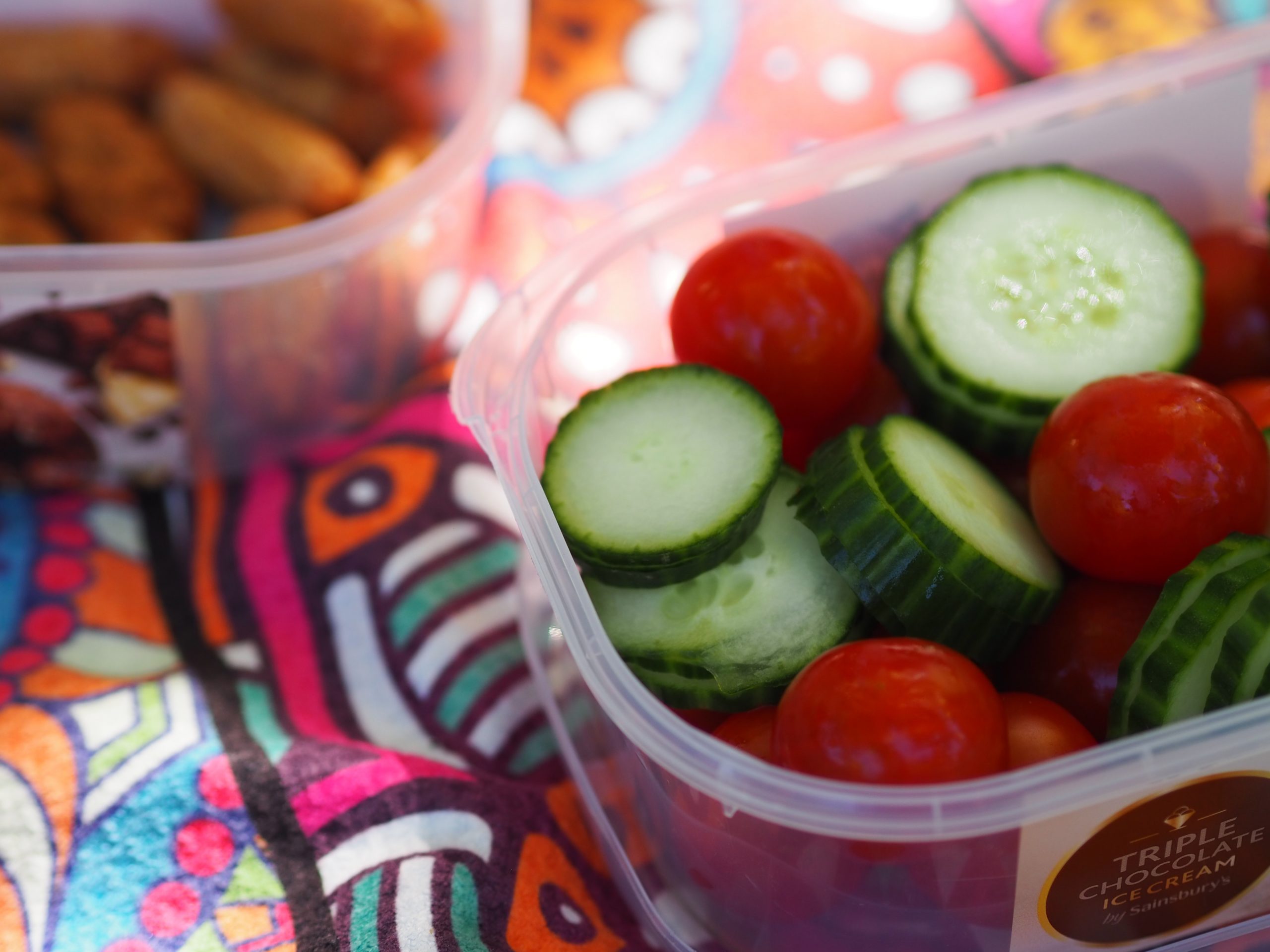 Tupperware boxes filled with vegetables and cocktail sausages 